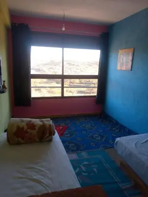 a bedroom with a window and a bed with a pillow at Auberge Assays in Taliouine
