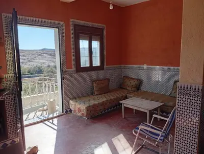 a living room with a couch and a table and a window at Auberge Assays in Taliouine