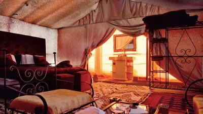 a bedroom with a bed and a couch in a room at Royal Sands Luxury Camp in Merzouga
