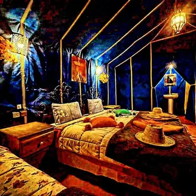 a bedroom with a bed with a hat on it at Royal Sands Luxury Camp in Merzouga