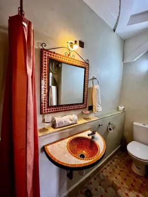a bathroom with a sink and a mirror at Jnane Ayam Atlas in Ourika