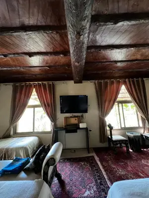 a bedroom with two beds and a flat screen tv at Jnane Ayam Atlas in Ourika