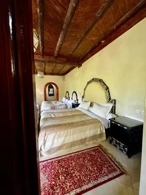 a bedroom with a large bed and a rug at Jnane Ayam Atlas in Ourika
