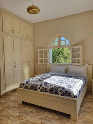 a bedroom with a large bed with a window at Villa Ourika ,Atlas in Ourika