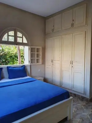 a bedroom with a blue bed and white cabinets at Villa Ourika ,Atlas in Ourika
