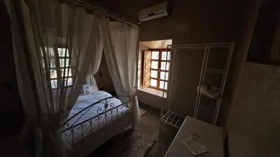 a small bedroom with a bed and a window at kasba Harmony in Oulad Saïd