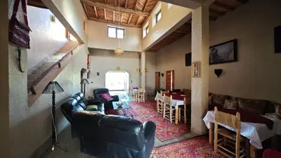 a living room with a couch and a dining room at kasba Harmony in Oulad Saïd