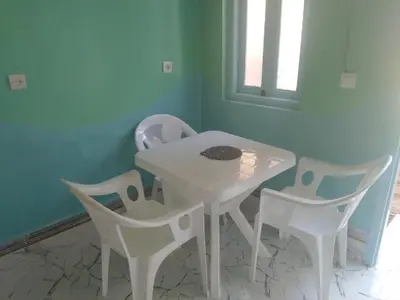 a white table and chairs in a room at Studio avec cuisine - kitchen in Tinerhir