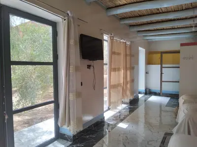 a living room with a tv and a sliding glass door at Studio avec cuisine - kitchen in Tinerhir