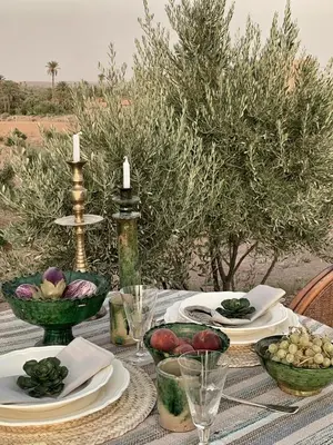 a table with plates and bowls of fruit on it at Dar faracha in Ouarzazate