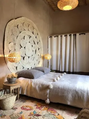 a bedroom with a large bed with a large wall at Dar faracha in Ouarzazate