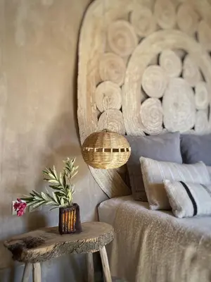 a room with a bed and a table with a mirror at Dar faracha in Ouarzazate