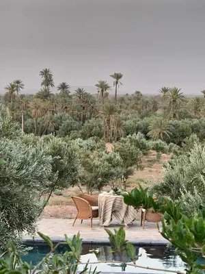 a table and chairs sitting next to a pool at Dar faracha in Ouarzazate