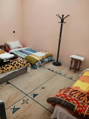 a room with two beds with arrows on the floor at chez l'habitant de compagne in Tamensourt