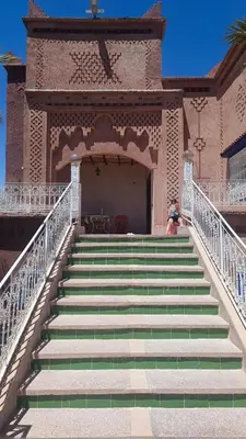 a staircase leading to a building with a person sitting on it at chez l'habitant de compagne in Tamensourt