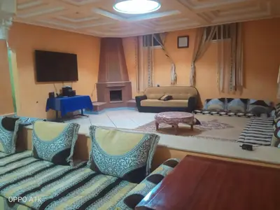 a living room with a couch and a tv at chez l'habitant de compagne in Tamensourt