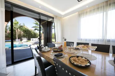 a dining room with a table and a pool at DAR KAYIS & LAILA in Marrakech