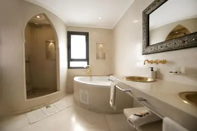 a bathroom with a tub and a sink and a mirror at DAR KAYIS & LAILA in Marrakech