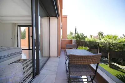 a patio with a table and chairs on a balcony at DAR KAYIS & LAILA in Marrakech