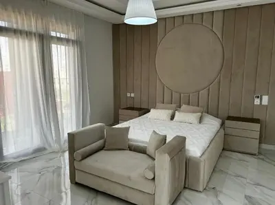 a bedroom with a bed and a couch and a mirror at Villa Magnolia Meknès Oasis de paix pour famille in Meknès