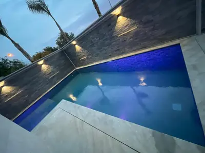 a swimming pool with lights on the side of a house at Villa Magnolia Meknès Oasis de paix pour famille in Meknès