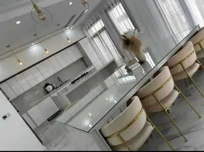 a kitchen with a glass table and gold chairs at Villa Magnolia Meknès Oasis de paix pour famille in Meknès