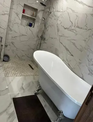 a white bath tub in a bathroom with marble walls at Villa Magnolia Meknès Oasis de paix pour famille in Meknès