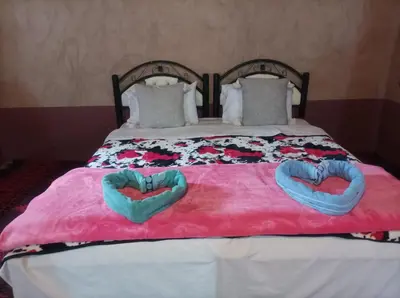 a bed with two heart shaped towels on it at Bivouac Sahara Passions in Mhamid