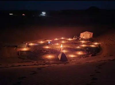 a group of lights on a beach at night at Bivouac Sahara Passions in Mhamid