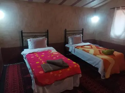 two beds sitting next to each other in a room at Bivouac Sahara Passions in Mhamid