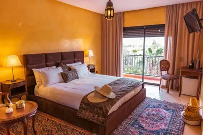 a hotel room with a bed and a balcony at Villa pension complète Marrakech in Marrakech
