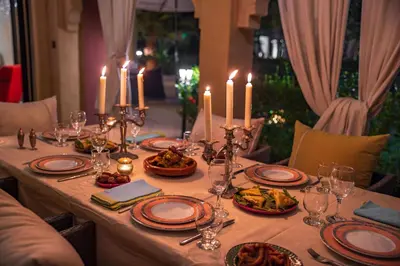 a table with candles and plates of food on it at Villa pension complète Marrakech in Marrakech