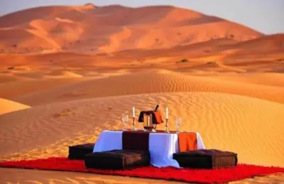 a table in the middle of a desert at Merzouga Exclusive Camp in Merzouga