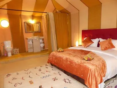 a hotel room with a bed and a bathroom at desert luxury merzouga in Merzouga