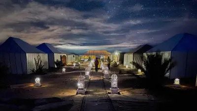 a group of buildings with lights at night at desert luxury merzouga in Merzouga