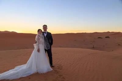 a bride and groom standing in the desert at desert luxury merzouga in Merzouga