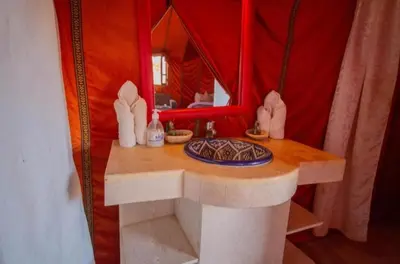 a table in a tent with a plate on it at desert luxury merzouga in Merzouga