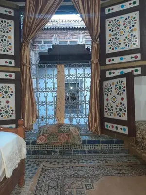 a bedroom with a bed in a room with curtains at suite 3 people Naima mbarki in Fès