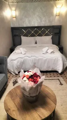 a bedroom with a bed and a table with flowers on it at Riad Diamant Bleu in Fès