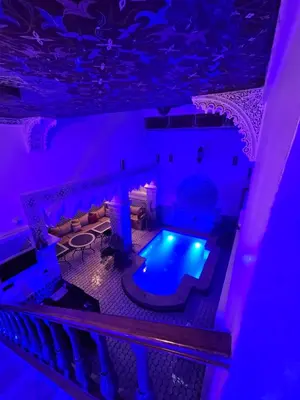an indoor pool in a room with purple lighting at Riad Diamant Bleu in Fès