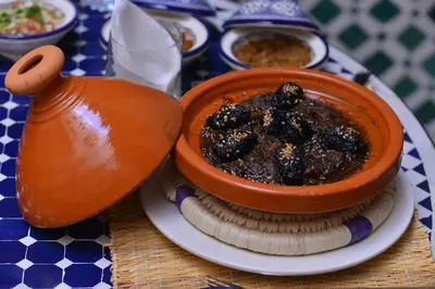 a bowl of food on a plate on a table at Riad Diamant Bleu in Fès