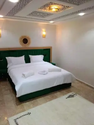 a bedroom with a large bed with white sheets at Riad Diamant Bleu in Fès