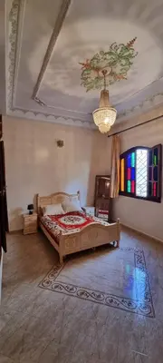 a bedroom with a bed and a chandelier at Villa with riad style in Fès