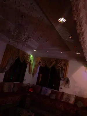 a living room with a couch and two windows at Villa with riad style in Fès