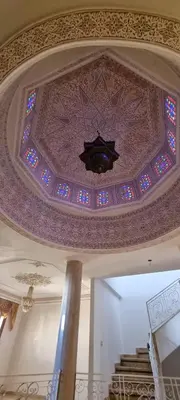 a room with a ceiling with a chandelier and stained glass at Villa with riad style in Fès