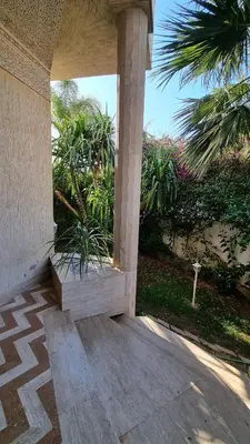 a porch of a house with a palm tree at Villa with riad style in Fès