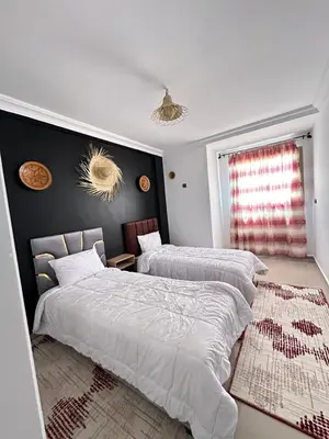 a bedroom with two beds and a window at Hood houses in Ouarzazate