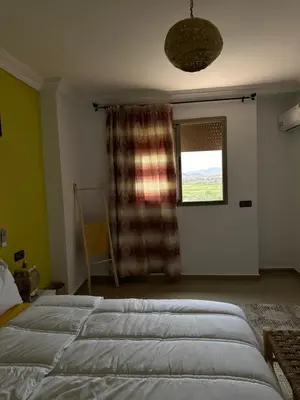 a bedroom with a large bed and a window at Hood houses in Ouarzazate