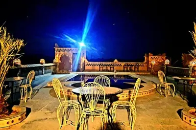 a patio with chairs and a table and a pool at Riad Dar Maria in Merzouga