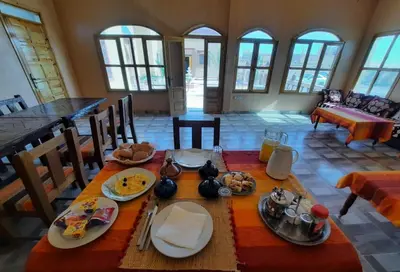 a dining room with a table with food on it at Riad Dar Maria in Merzouga
